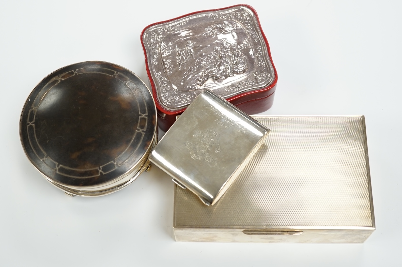 A George V silver and tortoiseshell mounted circular trinket box, Birmingham, 1923, 10cm, a silver cased travelling timepiece and two other silver mounted boxes including cigarette box.